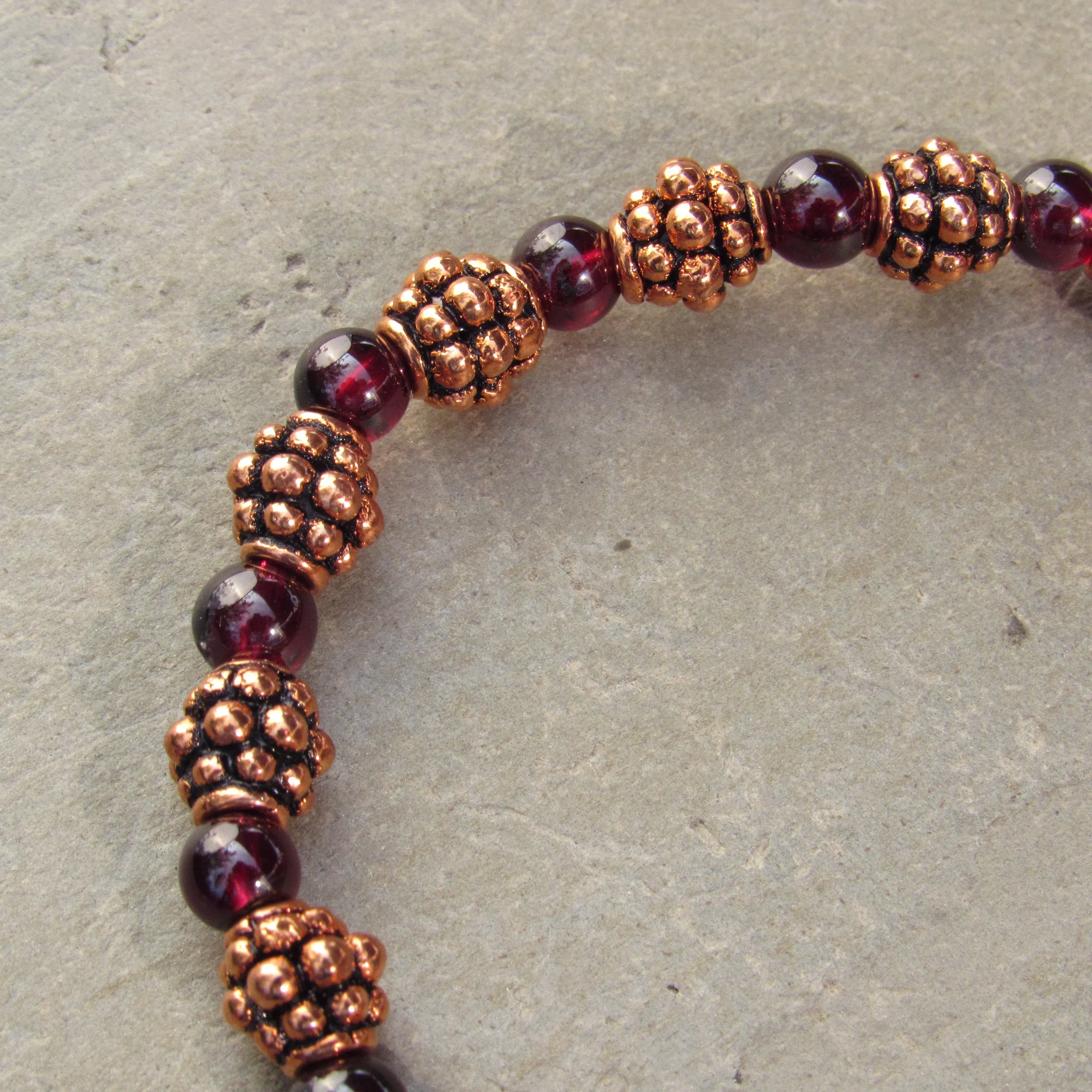 Garnet gemstones and copper bracelet